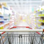 Supermarket,aisle,with,empty,red,shopping,cart.