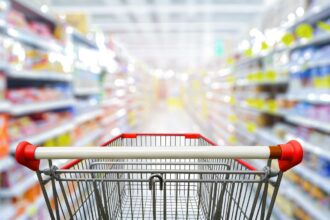 Supermarket,aisle,with,empty,red,shopping,cart.