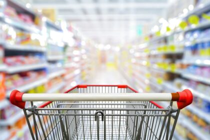 Supermarket,aisle,with,empty,red,shopping,cart.