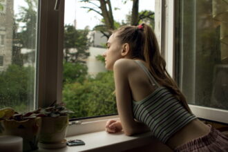 Bigstock A Young Teenager Girl Looks Ou 372672154
